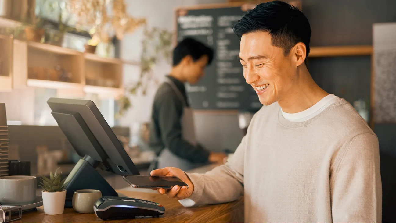 カフェのレジでモバイル決済をするシーン