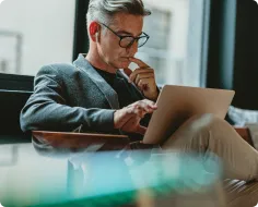 座りながらパソコンで仕事をしている男性